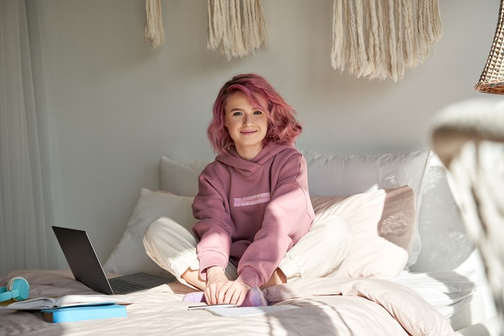 Pubermeisje roze haar lezend op bed